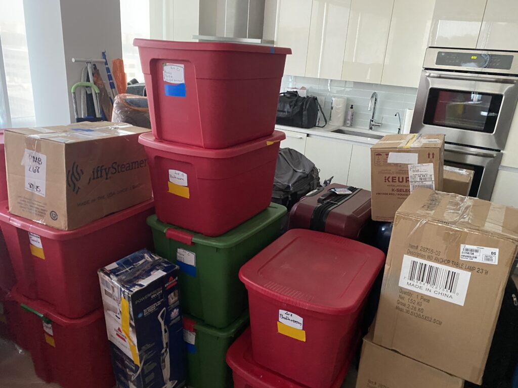 Color-coded moving bins and labeled boxes packed in a kitchen before relocation.