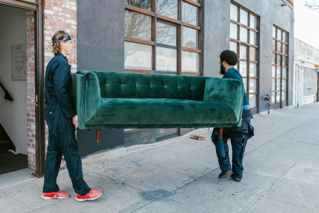 Movers carrying a sofa into a house for local and interstate moves