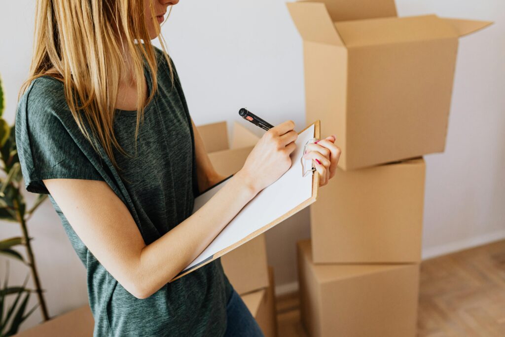 person checking off items on moving checklist for relocation
